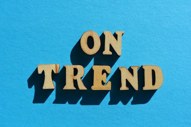 On Trend words in wooden alphabet letters isolated on blue background