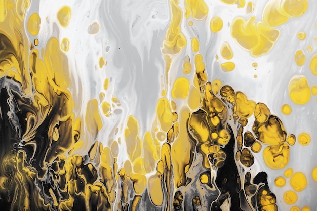 Trending colors of 2021. Flow of gray paint with yellow bubbles drops. Marble effect background or texture. Fluid Art.