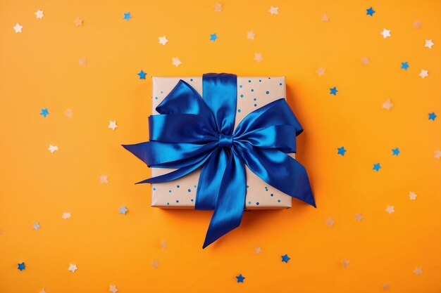 Trendy attractive gift with blue bow on the orange background with stars merry christmas