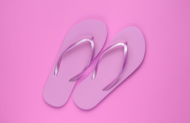 Trendy beach pink flip flops on pink paper