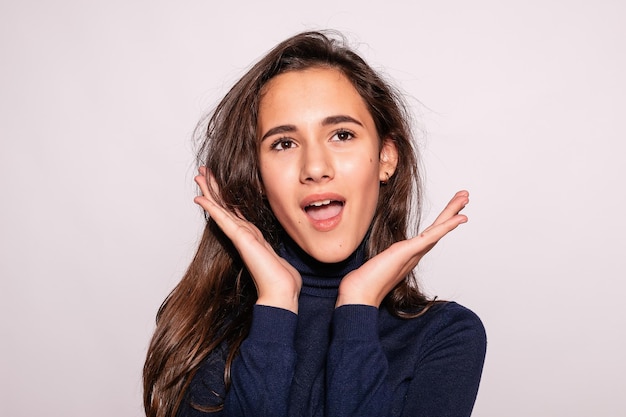 Trendy beautiful hipster girl Photo of positive young nice woman in blue kneehigh socks with white background looks at the camera surprised with his hand and look up