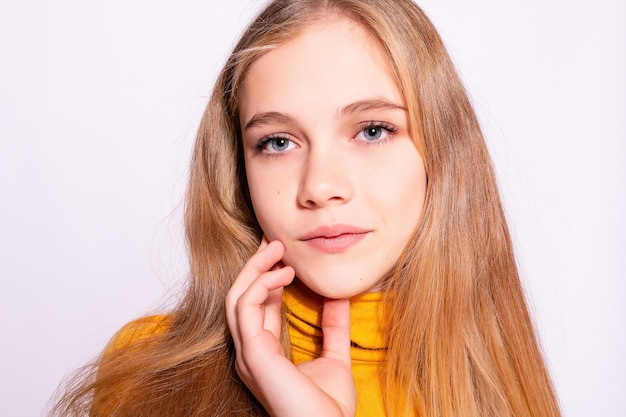 Trendy beautiful hipster girl. Photo of positive young nice woman in yellow knee-high with white background. hands on the face