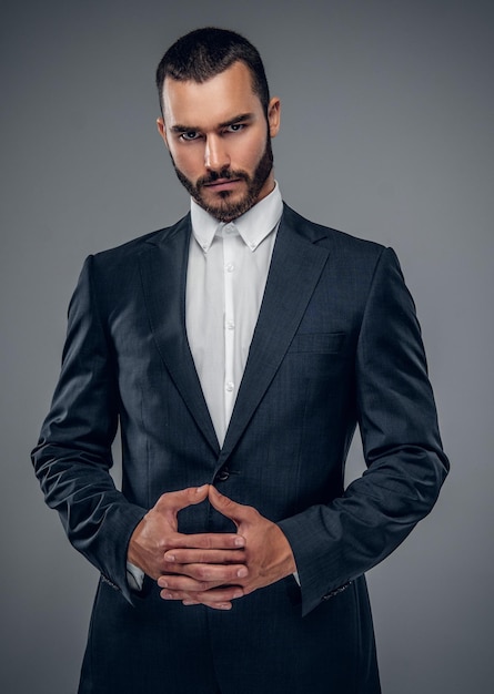 A trendy business man in a suit isolated on grey background.