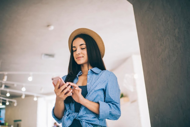 Trendy dressed hipster girl checking received email message during networking time using 4g wireless