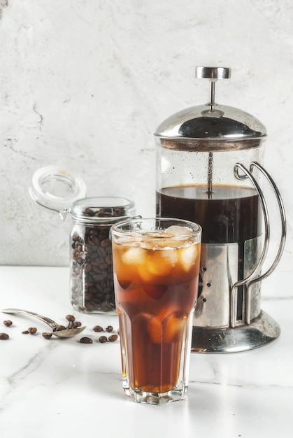 Trendy drinks. Cold brew iced coffee on white marble table. copy space