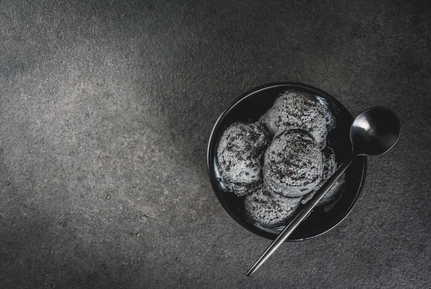 Trendy food. Black ice cream with black sesame, in a black bowl