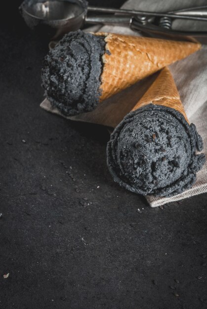 Trendy food. Black ice cream with black sesame, in traditional portioned ice cream cones