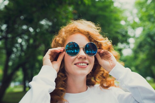 trendy gemberhaar jonge vrouw in zonnebril