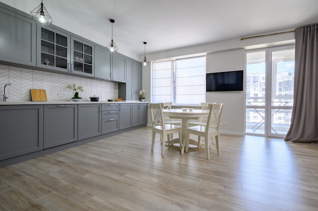 Trendy grey and white modern kitchen furniture in studio apartment