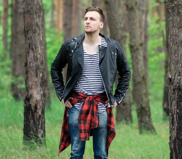 Trendy guy is resting in a pine forest
