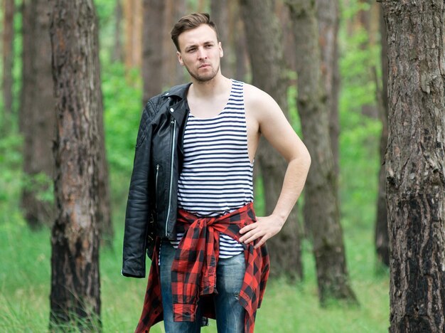 Trendy guy is resting in a pine forest