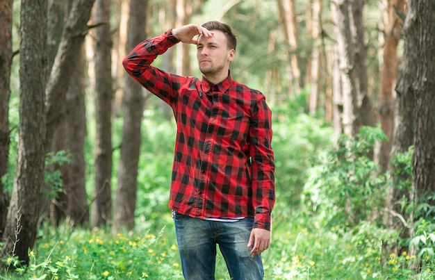 Trendy guy is resting in a pine forest