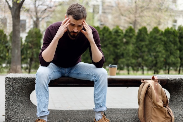 Trendy guy with , walking in the city a cup of coffee in hand. depressed guy