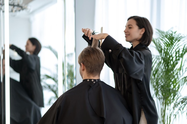 Foto taglio di capelli alla moda. parrucchiere dai capelli scuri che lavora su un taglio di capelli alla moda