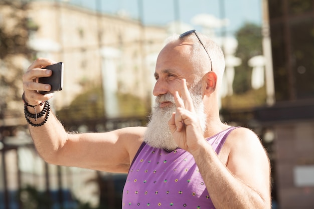 Trendy hogere mens die smartphone in centrum van de binnenstad gebruiken openlucht - Rijp maniermannetje die pret met nieuwe tendenstechnologie hebben - Technologie en blij bejaard levensstijlconcept