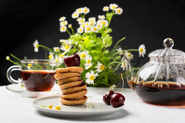 A trendy homemade breakfast with mini pancakes and cherries on the table in a plate Horizontal orientation