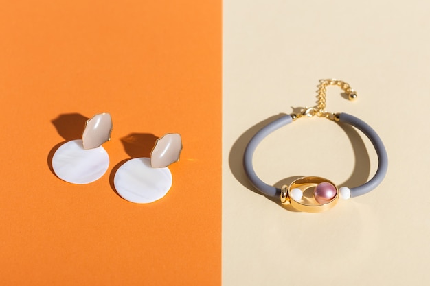 Trendy jewelry on coloured surface