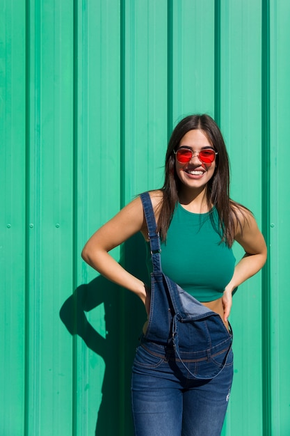 Trendy jonge vrouw die zich door de groene muur