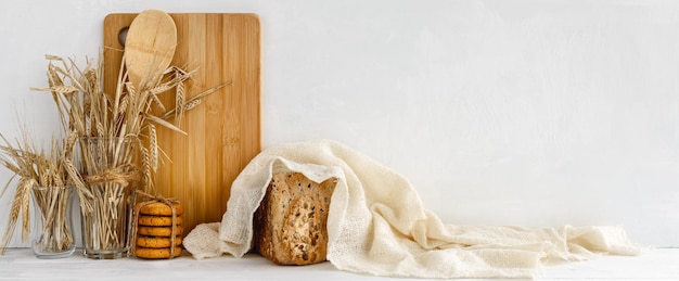 Trendy keukenbanner zelfgebakken brood en houten keukengerei op een witte tafel Voorraadbanner en kopieerruimte