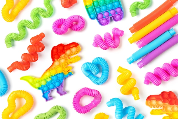 Giocattoli per bambini alla moda ãâ€â” colorati tubi pop e pop-it su sfondo bianco. set di diverse forme e colori tubi corrugati e giocattoli per le dita fidget.