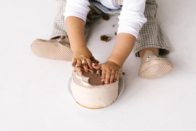 Trendy Koreaans dessert bento cake beige kleur zal worden verpletterd in de handen van een klein kind Dessert voor de eerste verjaardag van de baby