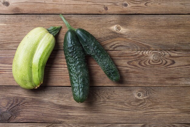 Trendy lelijke organische natuurlijke pompoen en komkommer op natuurlijke houten tafel. Kopieer ruimte.