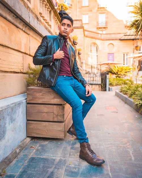 Trendy levensstijl van een Latino man in de stad. Jeans, leren jas en bruine schoenen