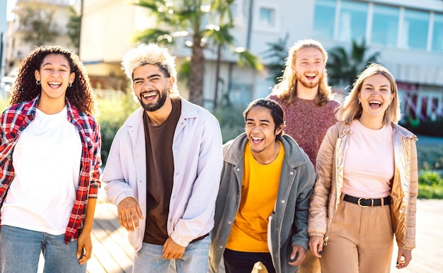 Trendy life style concept with multicultural friends walking together at city boardwalk