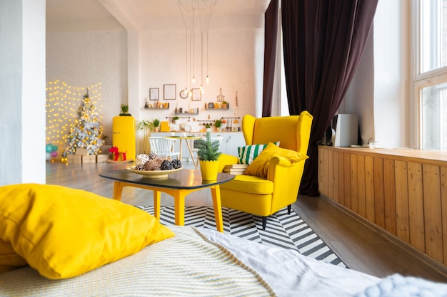 Trendy luxe mode-interieur in Scandinavische stijl van studio-appartement met felgele meubels en gedecoreerd met verlichting