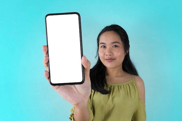 Модный мобильный телефон Возбужденная милая азиатка держит смартфон с пустым белым экраном