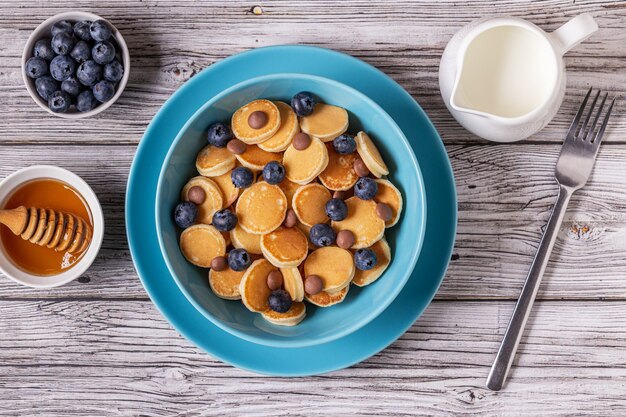 Trendy ontbijt met mini pannenkoeken, bosbessen en chocoladeschilfers