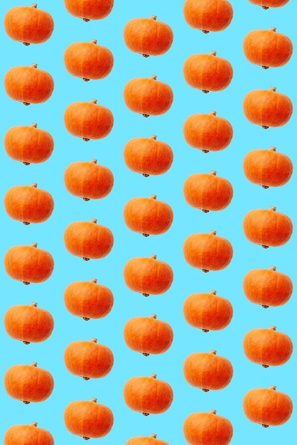 写真 青色の背景の上面にオレンジ色の装飾的なカボチャとトレンディなパターン