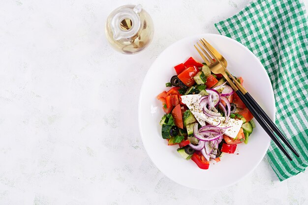 Trendy salade. griekse salade met verse groenten, fetakaas en zwarte olijven. gezond uitgebalanceerd eten. bovenaanzicht, boven het hoofd, plat gelegd