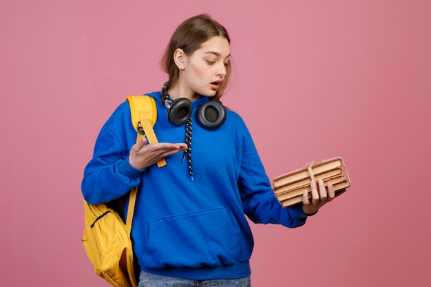 Trendy schoolmeisje dat een stel oude boeken vasthoudt