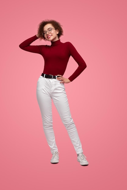 Trendy smiling woman standing in studio