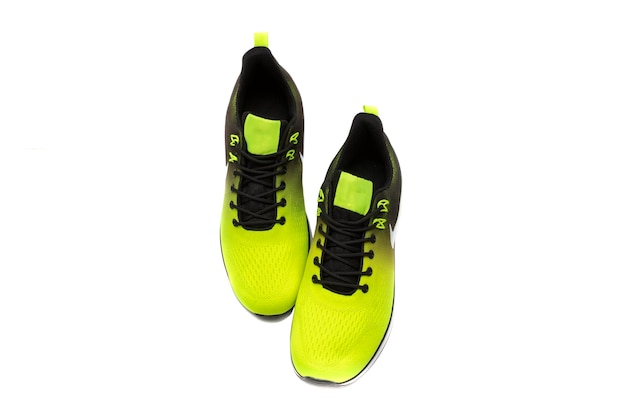 Trendy sports shoes, with a black and yellow color gradient, isolated on white background.