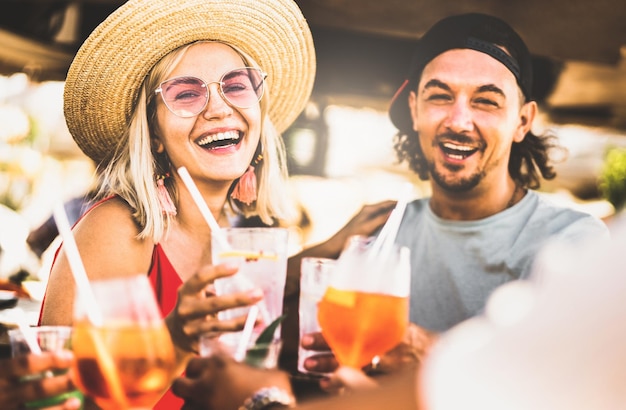 Trendy stel dat plezier heeft met het drinken van chique cocktails op het strandfeest