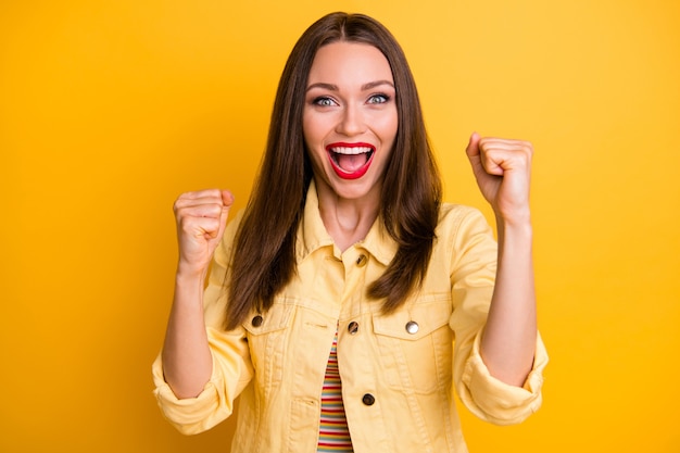 Foto ragazza carina allegra alla moda alla moda che fa i pugni che sreaming yeah rallegrandosi per un evento di successo che accade isolato muro di colori vivaci