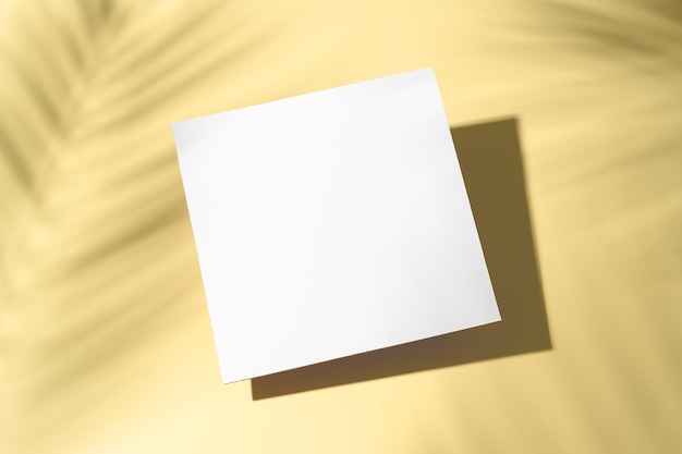 trendy summer layout made with white blank card and palm leaves shadow on pastel yellow background exotic concept with copy space