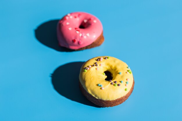 Trendy sunlight. Summer doughnuts on bright light blue turquoise background. Minimal summer concept. Pop art style. Donut