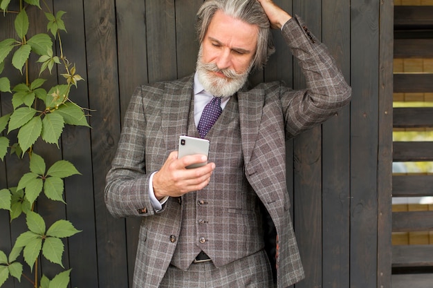 Foto trendy volwassen man met baard browsen telefoon