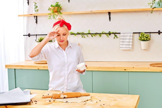 Trendy vrouw die gebakje op keukenlijst voorbereiden