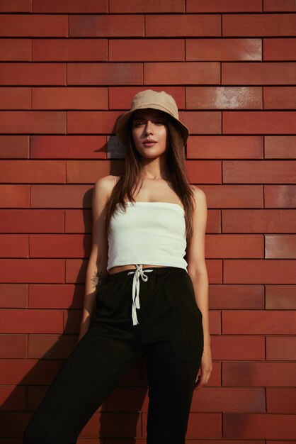 Trendy woman near brick wall in city