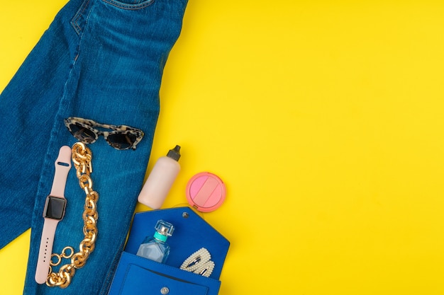 Trendy woman outfit with accessories on bright yellow background