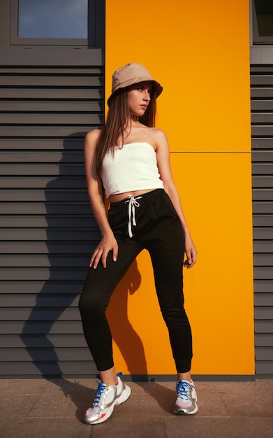 Trendy woman standing near building in city