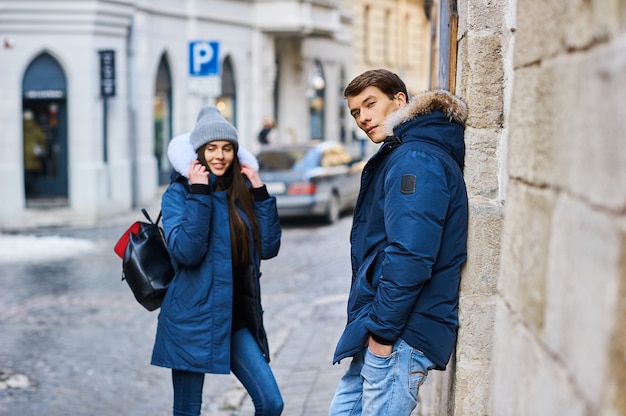 A trendy young couple walks in the city at christmastime