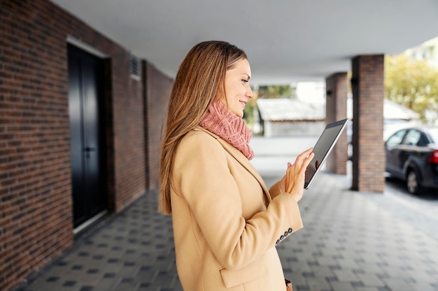 Foto trendy zakenvrouw met tablet op straat