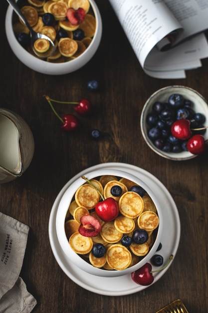 Trendy zelfgemaakt ontbijt, pannenkoekgranen, mini-pannenkoeken met bessen, bovenaanzicht