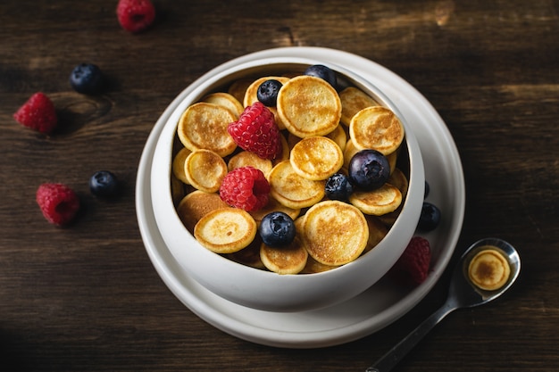 Trendy zelfgemaakt ontbijt, pannenkoekgranen, minipannenkoekjes met bessen