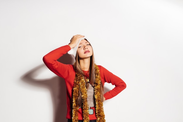 Treurige vrouw in een nieuwjaarskostuum op een grijze achtergrond